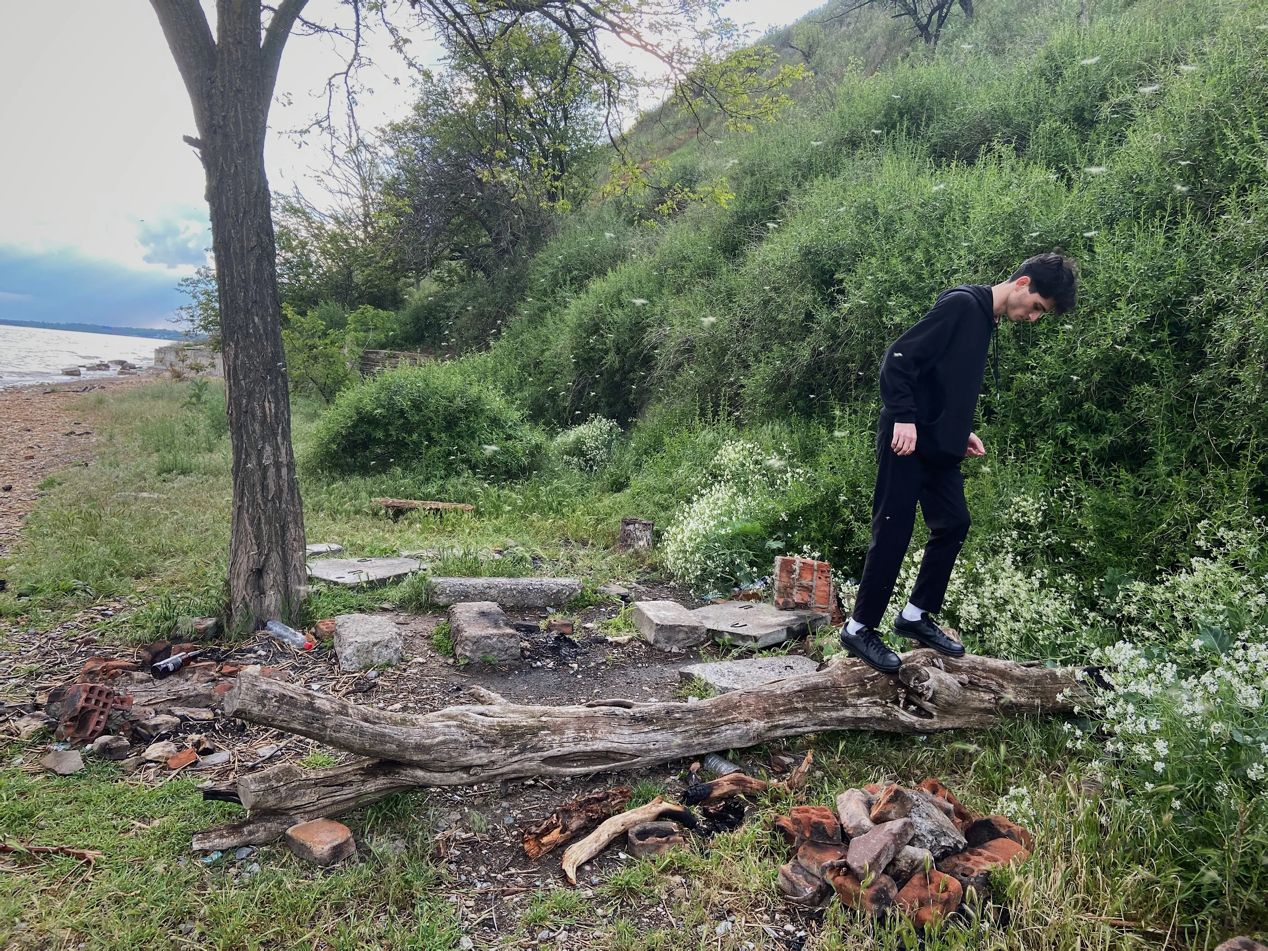 Seitenansicht eines Mannes, der im Wald neben Bäumen steht.